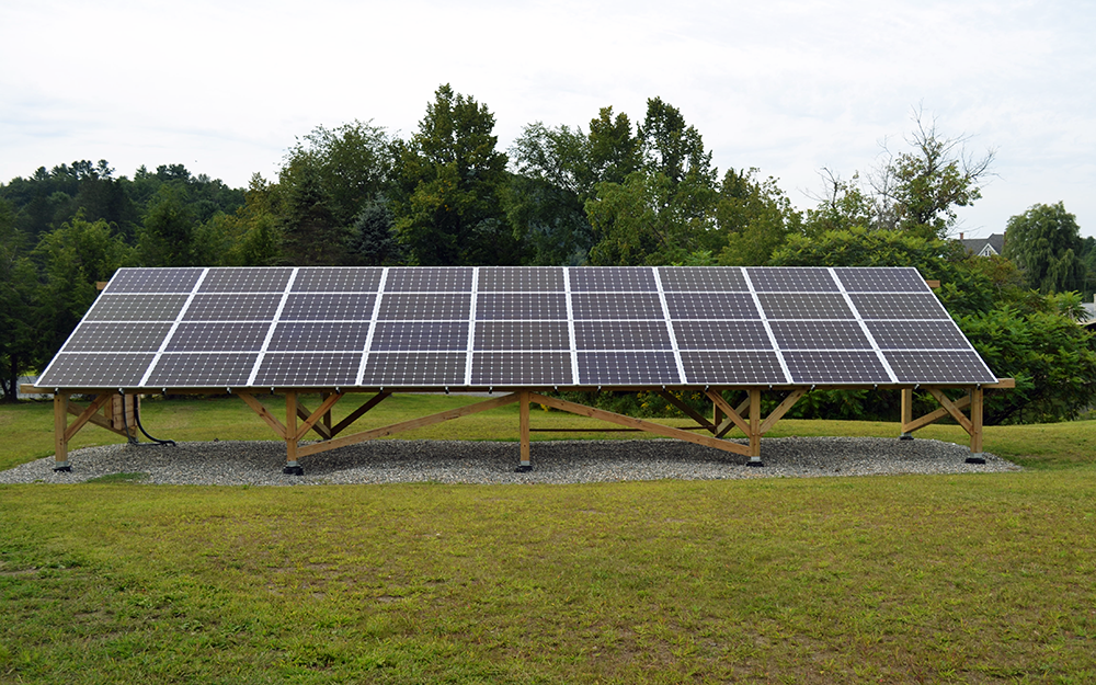 Wide-shot image of a solar panel array installed on a lawn at Vermont Law School.